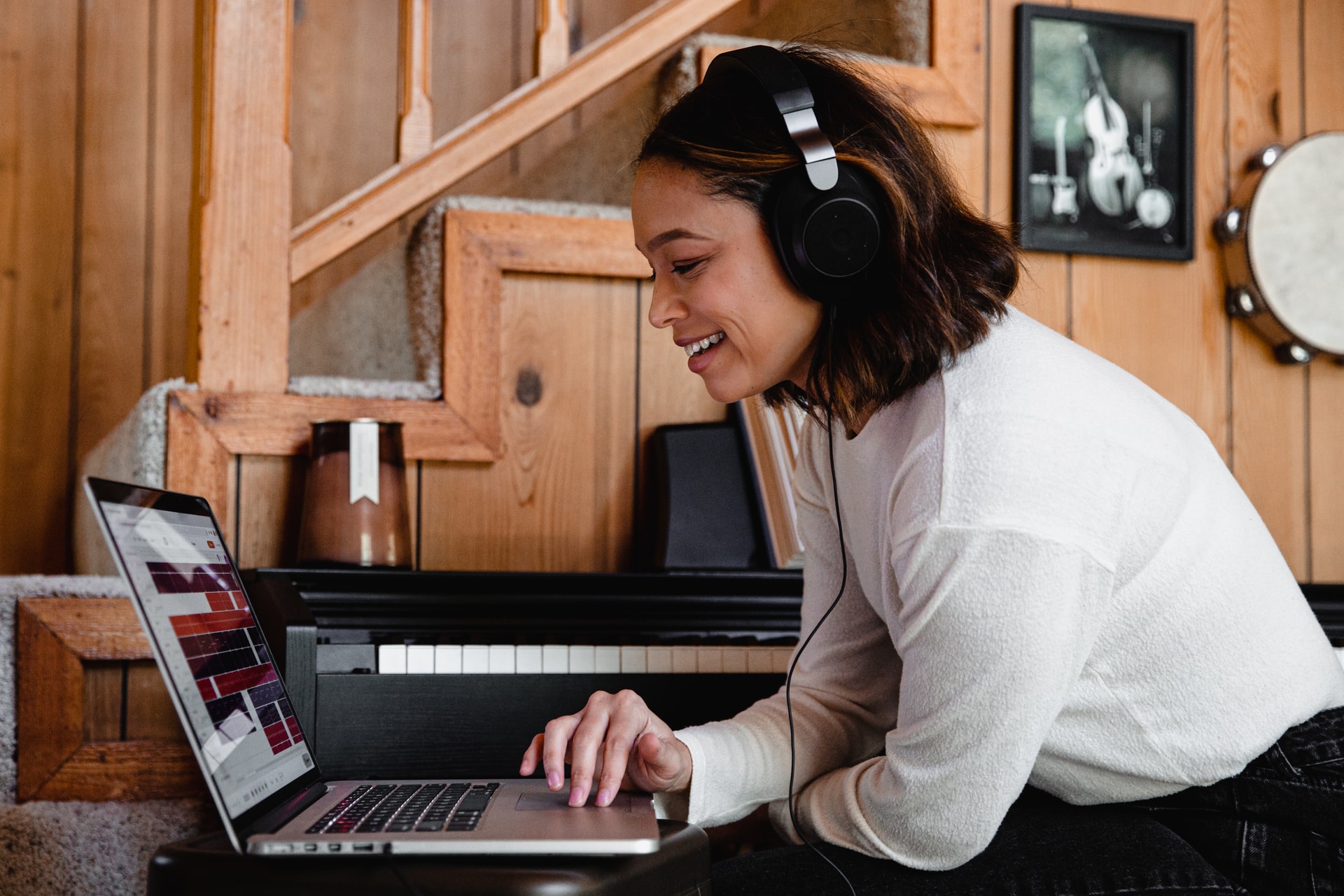 Mujer joven mirando su notebook mientras escucha música con audífono de casco