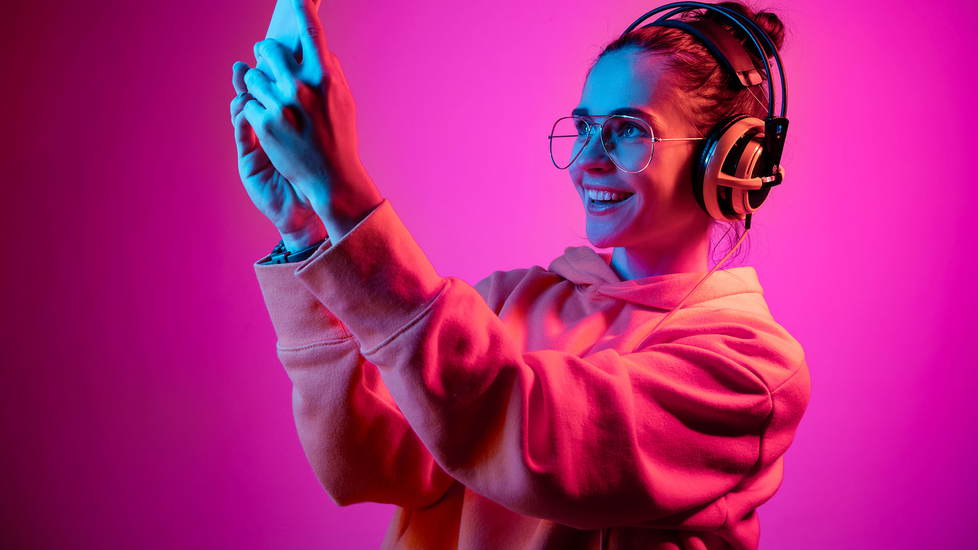 Mujer joven bajo luces de neón tomándose una selfie.